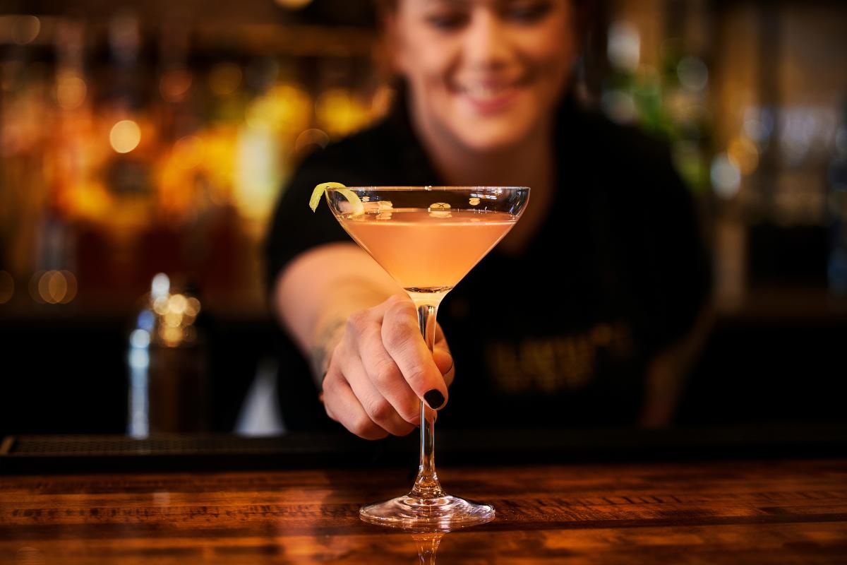 Woman shows off a drink in the Elephant Bistro