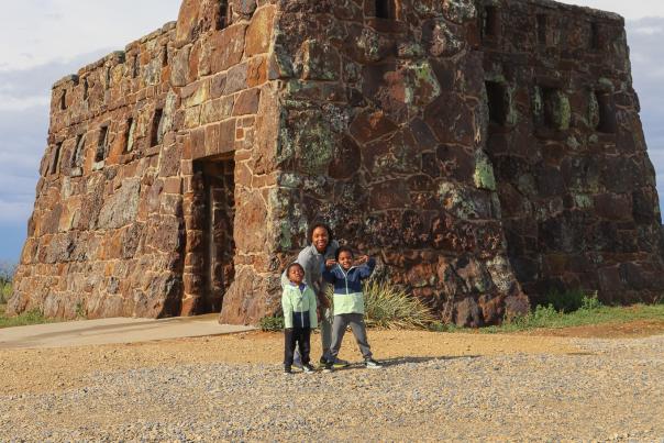 Three people stand by the castle at Coronado Heights