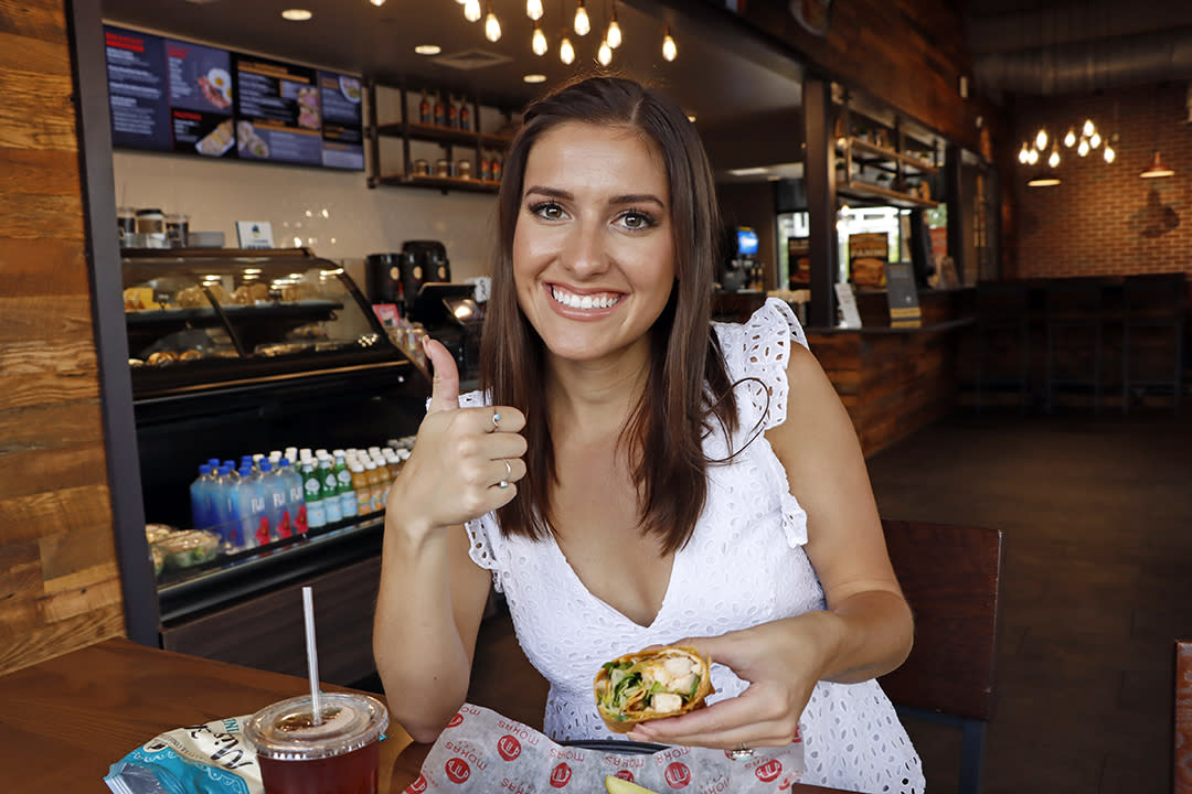 Woman sits on table and enjoys a meal