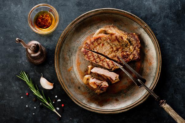 A piece of state sits on a plate with various seasonings surrounding it